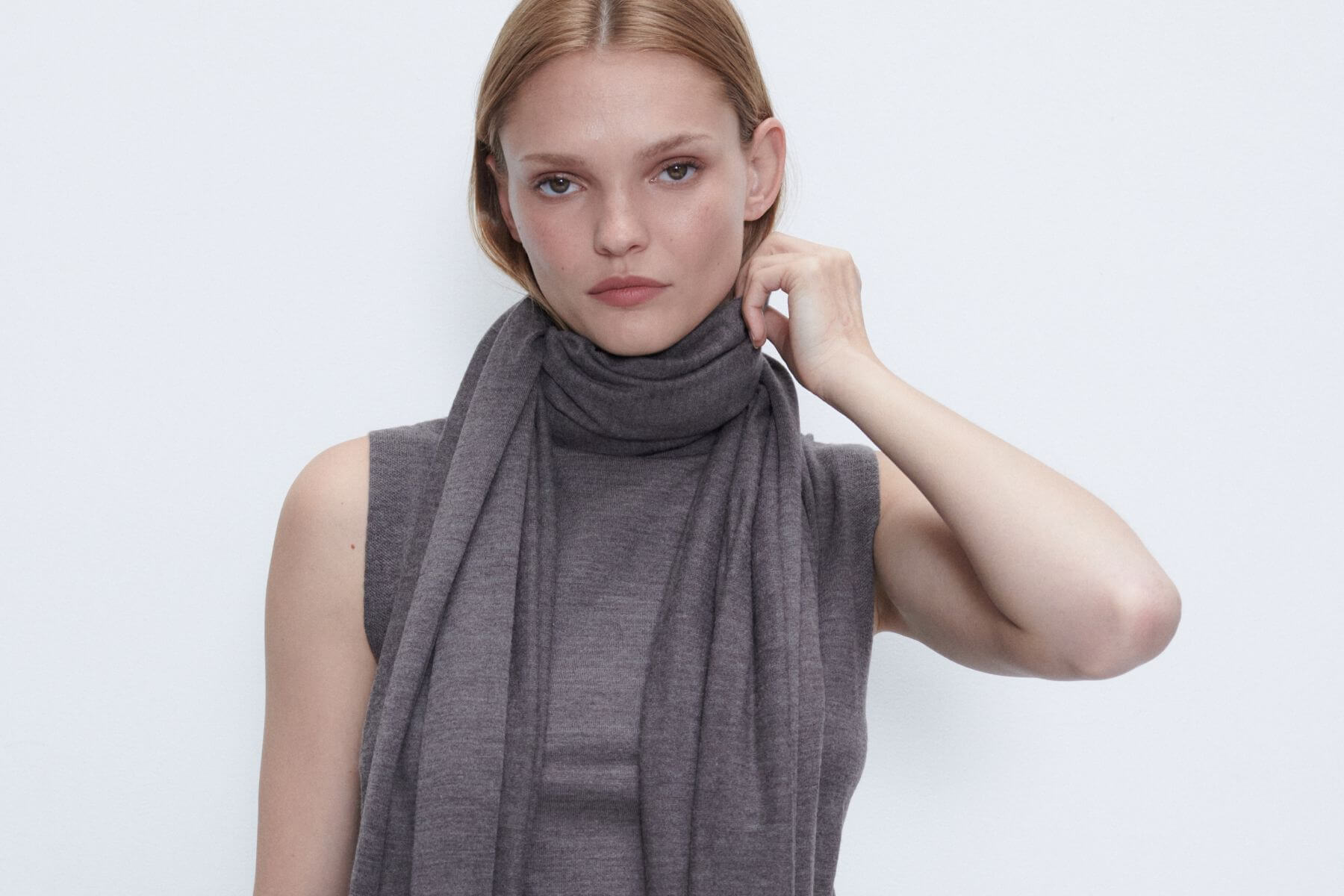 Close up of model wearing chocolate melange james sleeveless turtleneck and scarf.